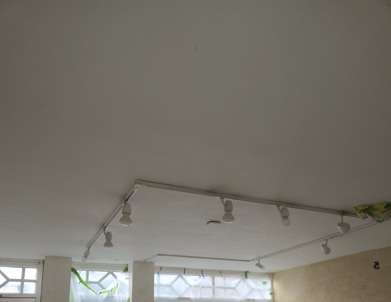 Existing retail unit ceiling with old track lighting fittings before the fit-out