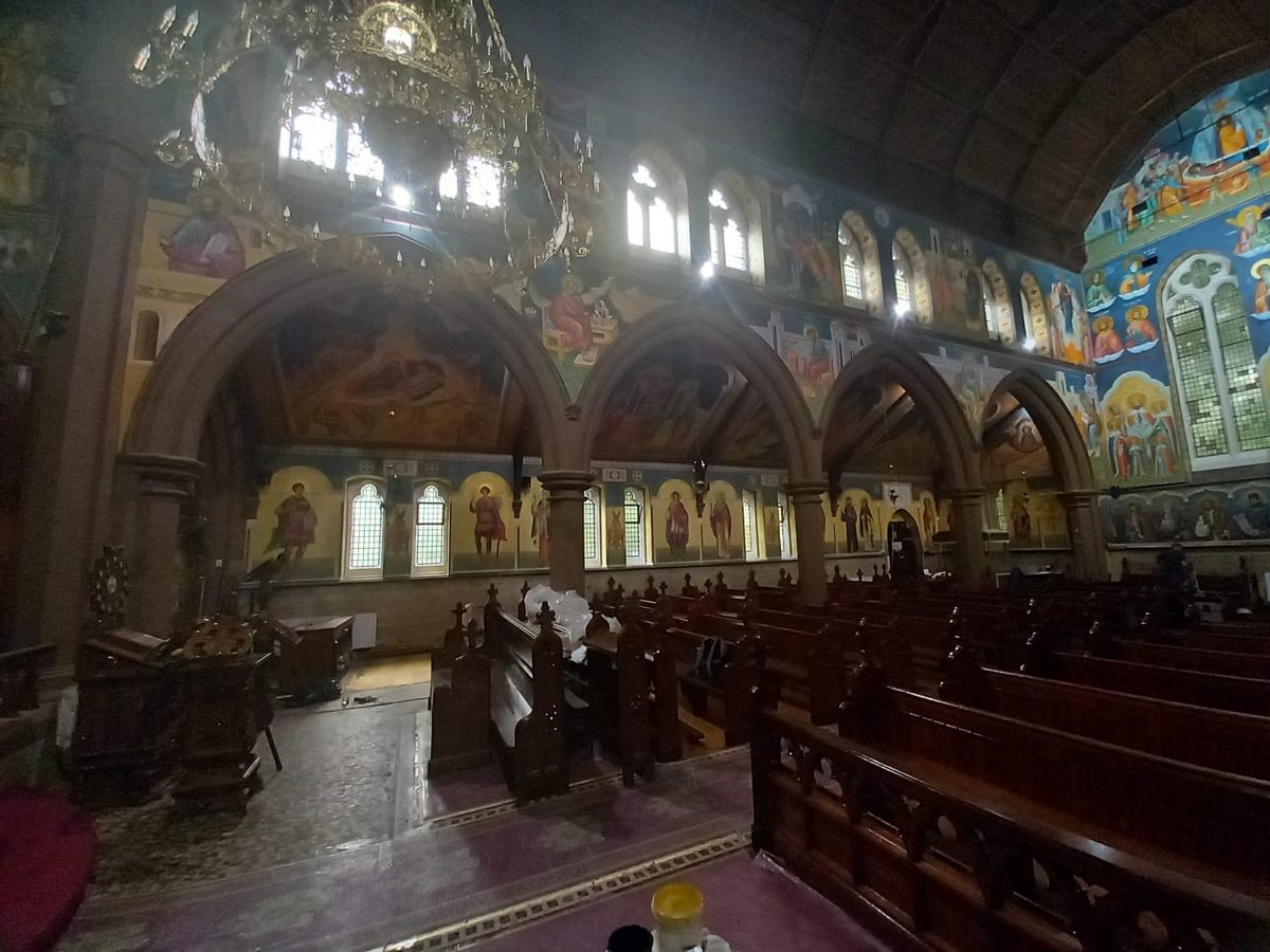 Church interior with poor, dim lighting, murals barely visible